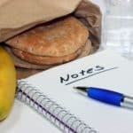 sandwich and banana in lunch bag with notepad and pen for what to bring on a personal retreat