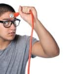 Conceptual image of a young man pull the plug from the outlet on his forehead.