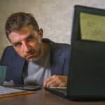 frustrated man working at office computer desk desperate and overwhelmed feeling upset suffering depression and anxiety crisis in financial business problem who needs to find motivation when you are stuck