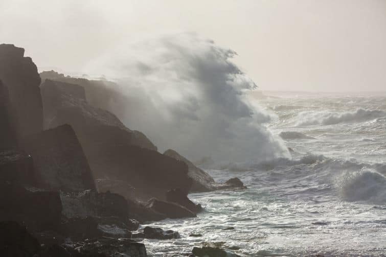 Big waves breaking on cliffs during winter storm on the west coast of Ireland. The waves wear down the stone in constant change