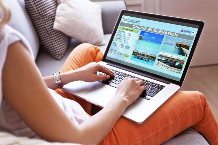 Woman using laptop to book hotel online for her personal retreat