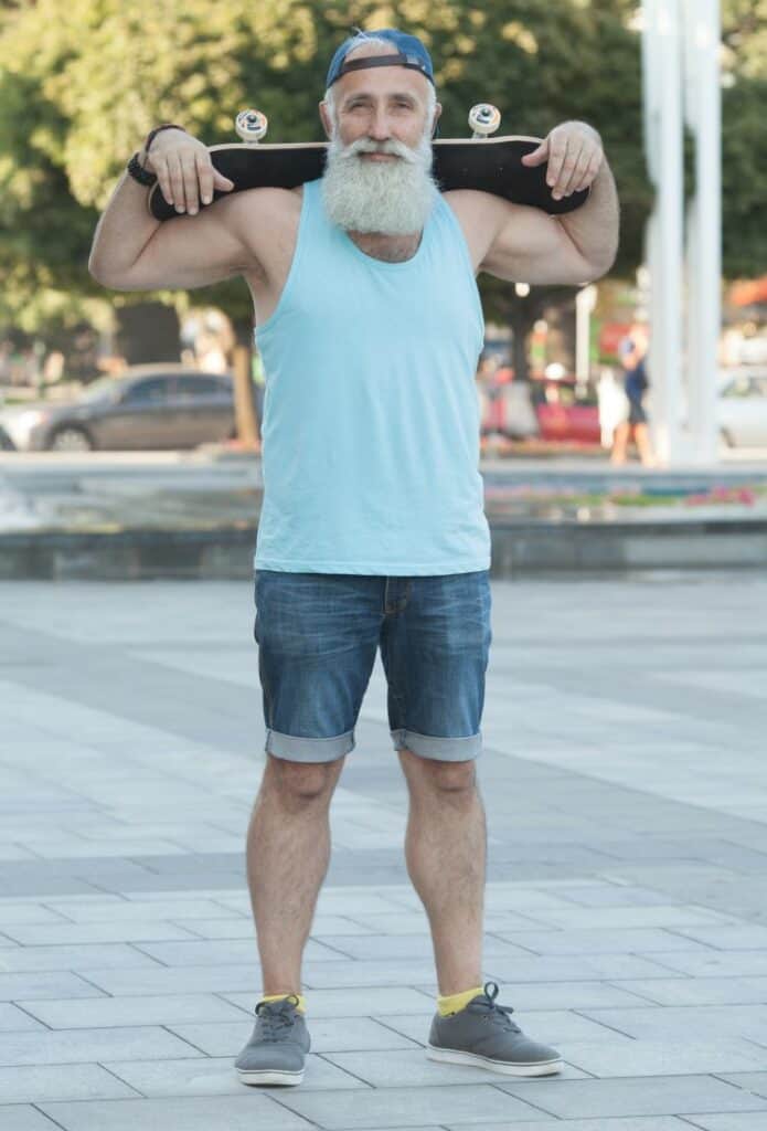 older man with shorts and a beard with a skateboard on his back he did find his purpose
